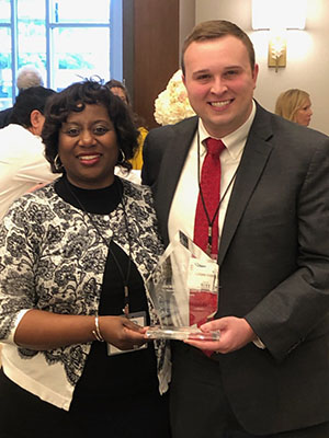 Dr. Loretta Jackson Williams, vice dean for medical education, and Logan Ramsey, M4, hold the GIVE Award presented to the Jackson Free Clinic by Volunteer Mississippi.
